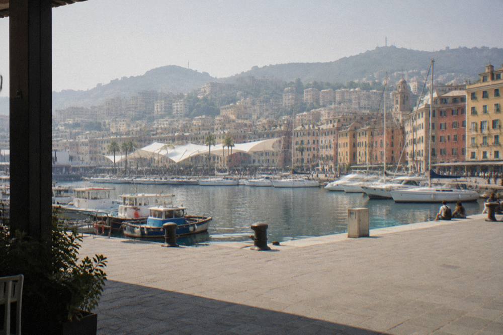 Fishing boats and waterfront buildings along the old harbour of a Ligurian port city