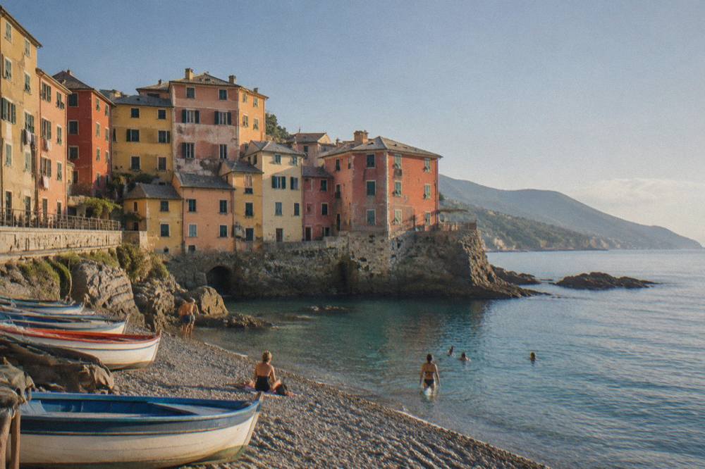 Swimmers entering the clear water from smooth rocks below a cliff-top promenade on the Ligurian coast