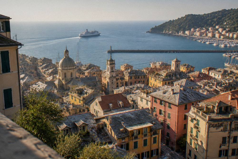 A ferry crossing the Ligurian Sea toward a wooded headland with a small harbour village