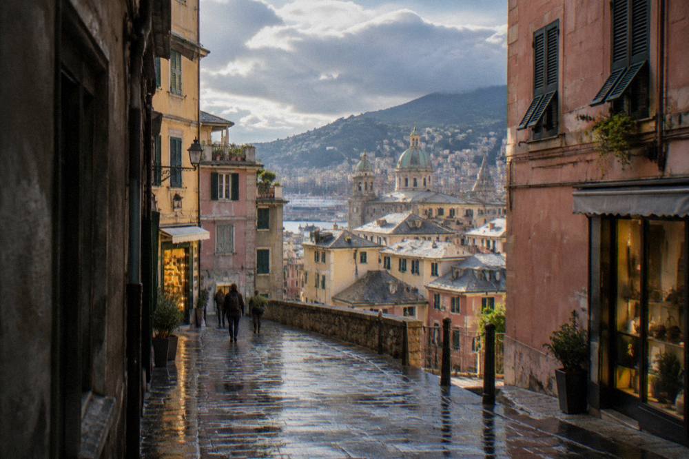 Wet cobblestone lane in the old town of Genoa with reflected shop lights after rain
