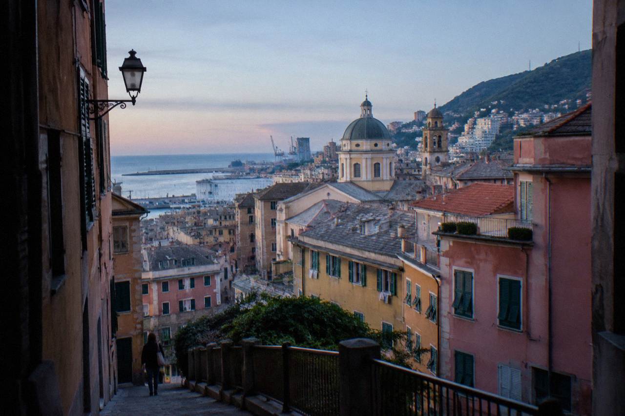 A street sign reading Genova on a stone wall in the old town of Genoa