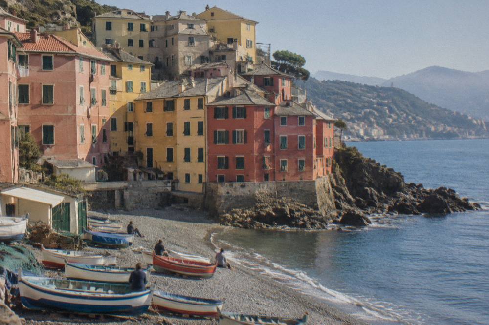 Fishing boats and colourful houses along the small beach at Boccadasse in Genoa