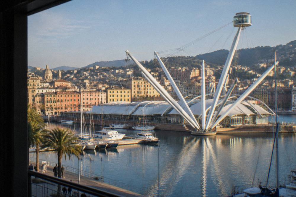 The Porto Antico waterfront in Genoa with the Bigo lift structure and moored boats under a clear sky