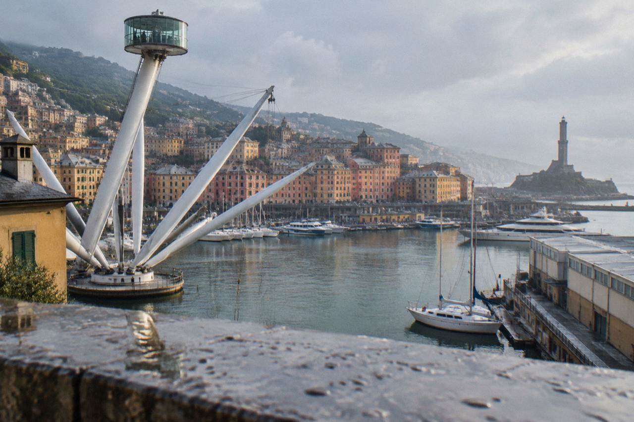 The Porto Antico harbour in Genoa with boats, the Bigo lift and the Lanterna lighthouse in the distance