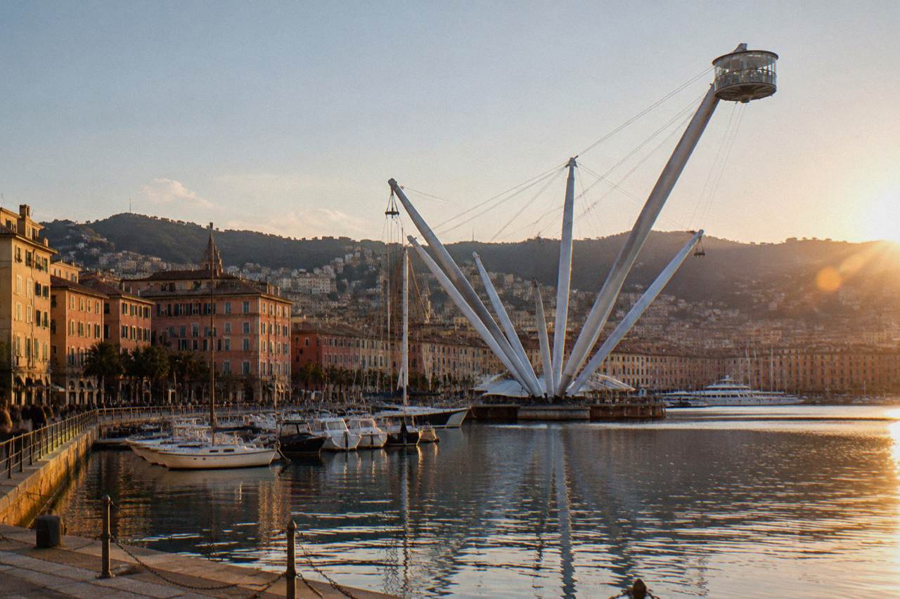 The old harbour of Genoa with the Bigo lift, moored boats and harbourfront buildings in evening light