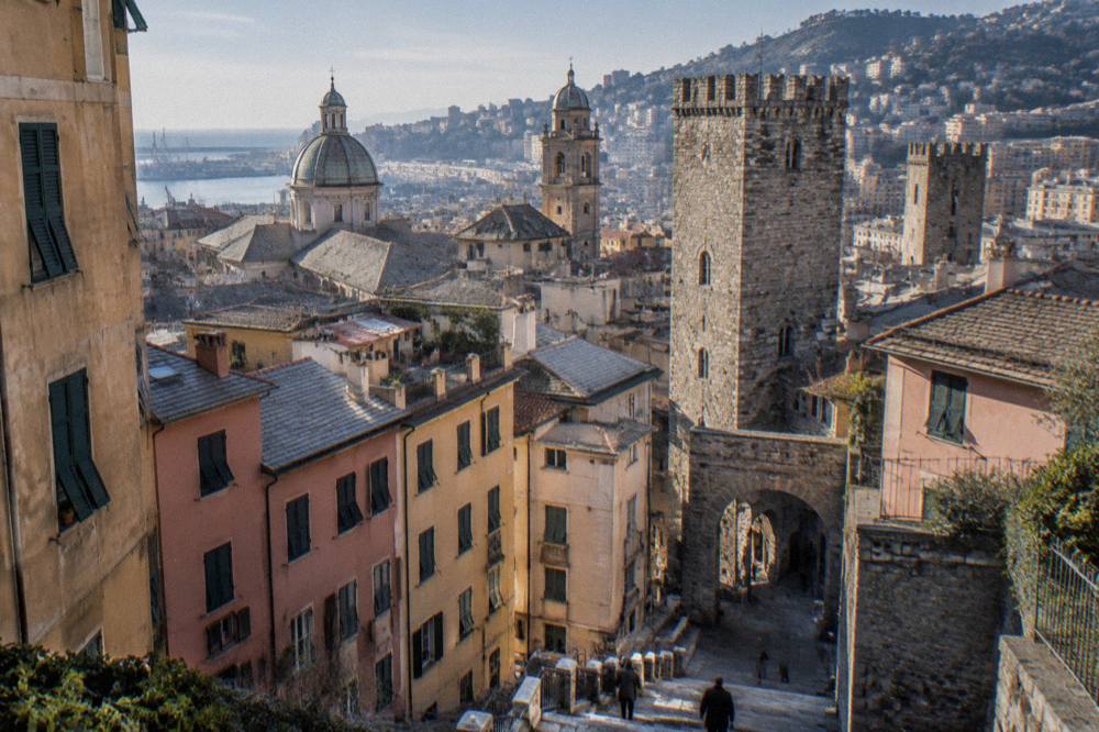 Stone towers and an old archway in central Genoa on a bright day