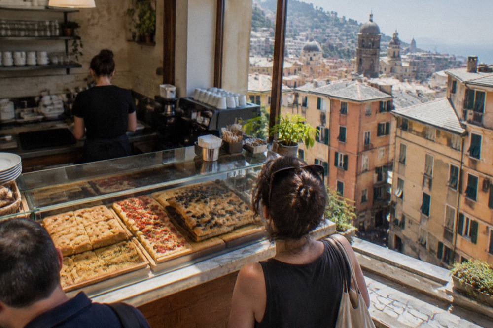 A café counter in Genoa with focaccia displayed behind glass
