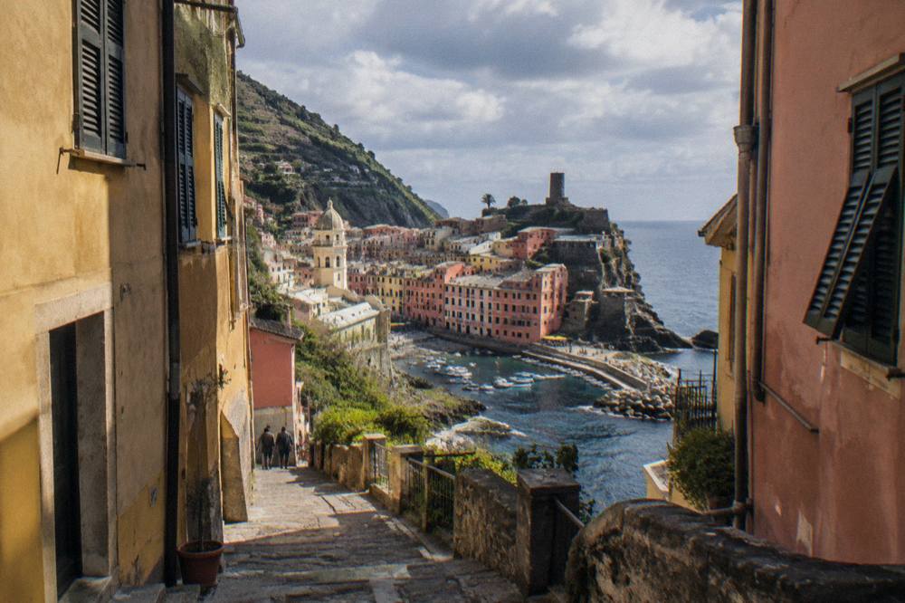 A narrow lane between tall painted buildings in an old Italian port town