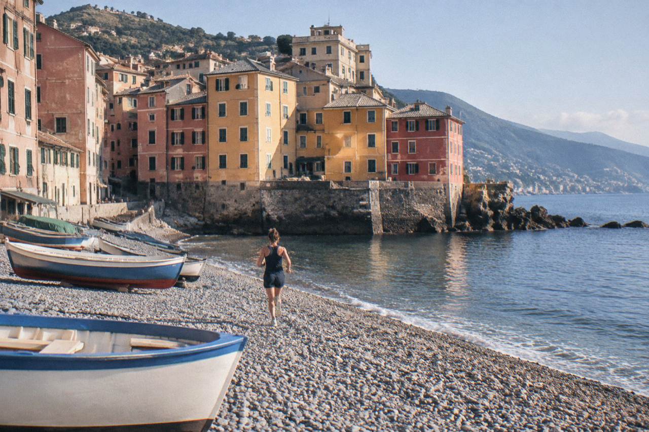 Colourful houses of Boccadasse clustered around a small pebble beach with fishing boats