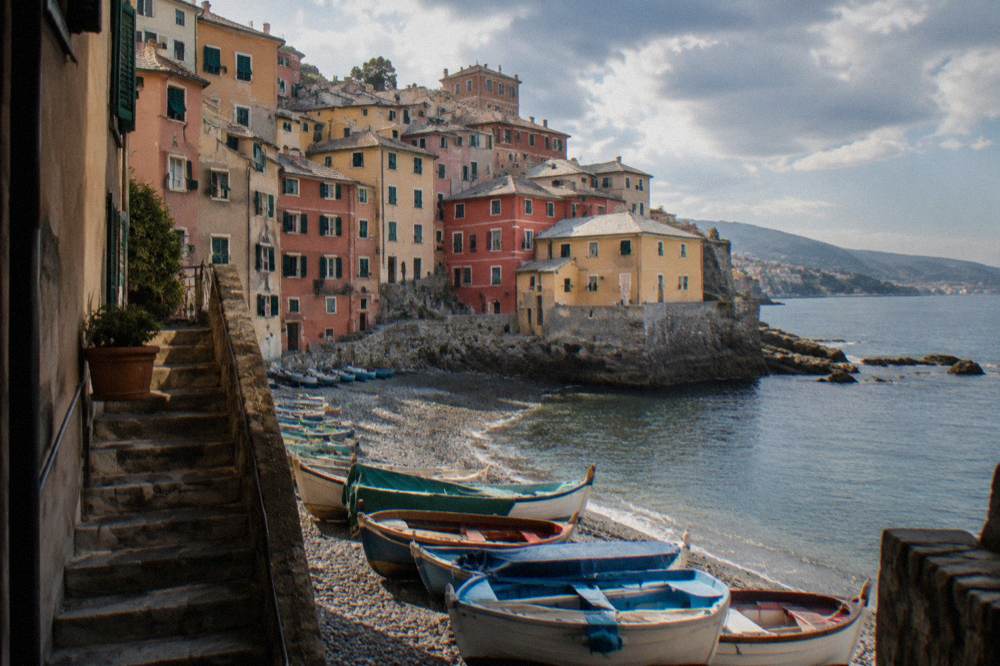 Stone staircase climbing between coloured houses above the Boccadasse bay