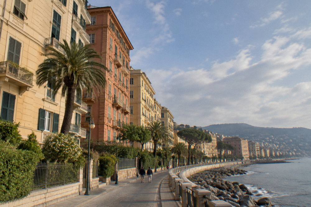 A long seaside promenade curving along a coastline with apartment blocks on one side