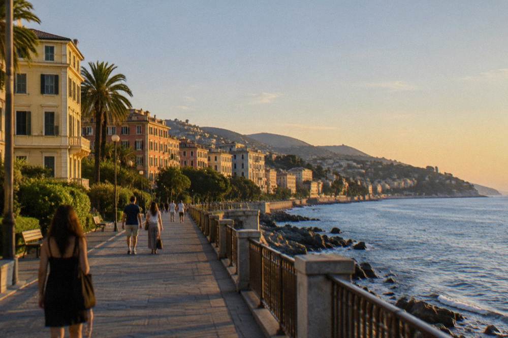 People walking a seaside promenade under a bright sky with the sea on one side