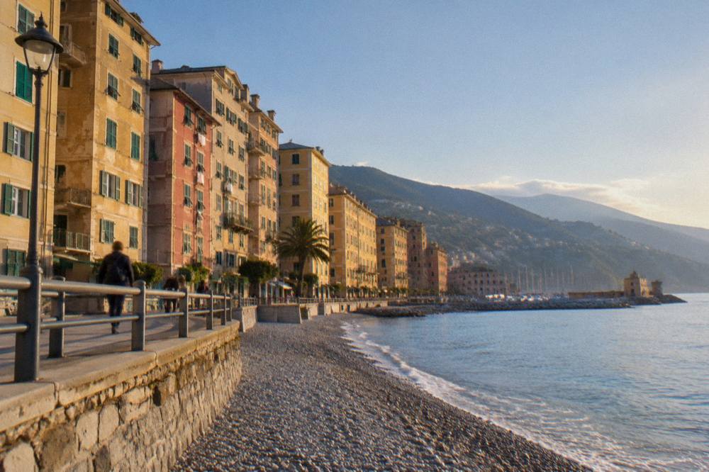An evening promenade with lit windows and calm sea along the coast