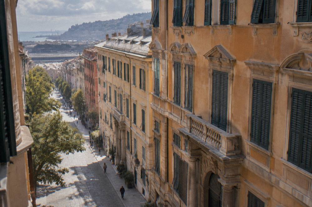 An ornate palace facade with shuttered windows on a narrow Italian street