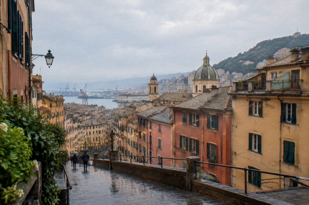 Rain-washed medieval lanes with tall buildings and strung lights in an Italian old town