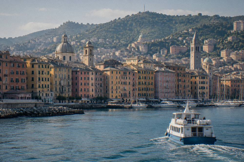 A boat leaving the old harbour of Genoa heading along the Ligurian coast