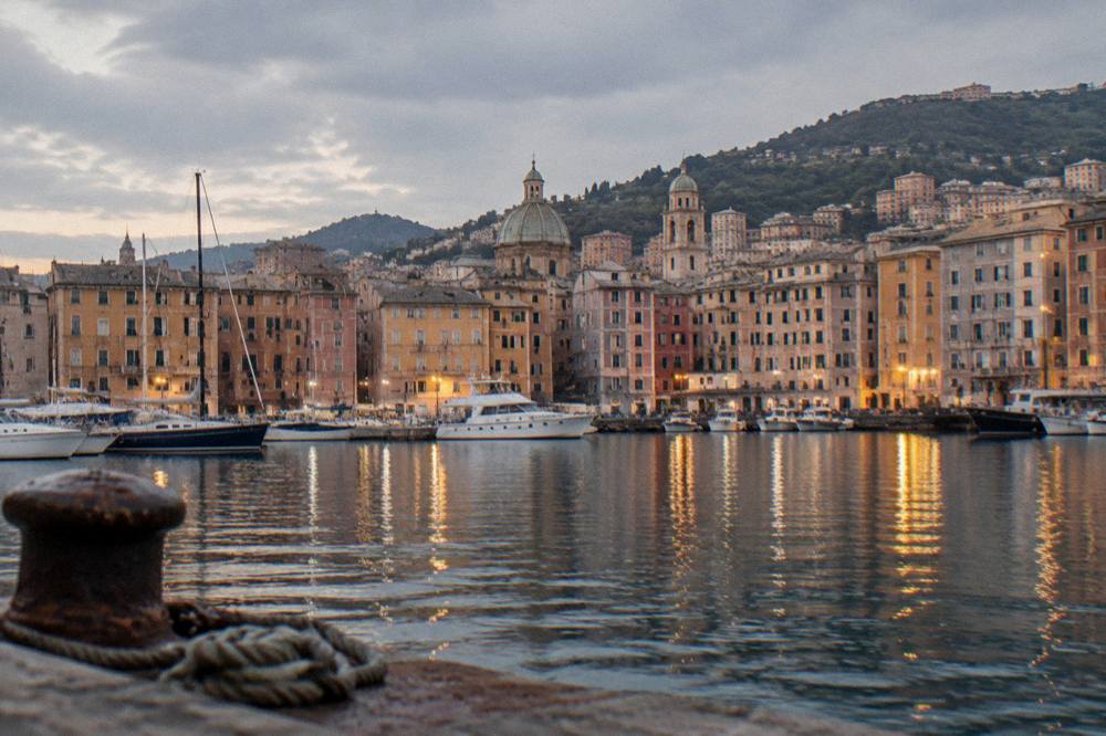 The lights of the old harbour of Genoa reflecting on the water at dusk