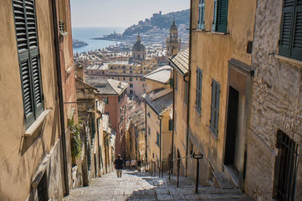 Narrow stepped lane in Genoa's old town with old stone buildings on both sides