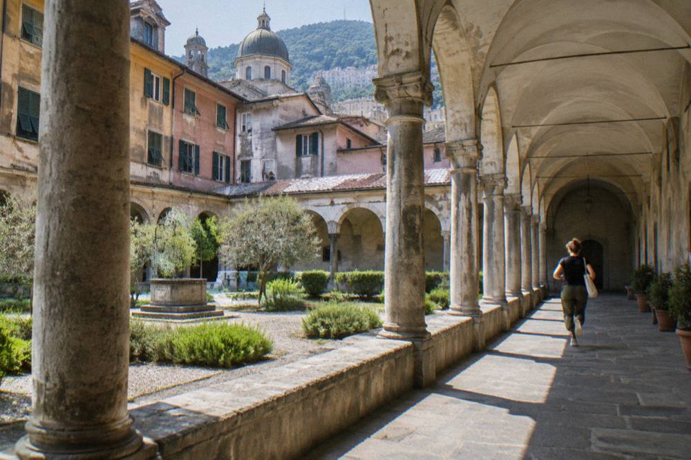 Cloister with stone arches and columns in a quiet corner of Genoa