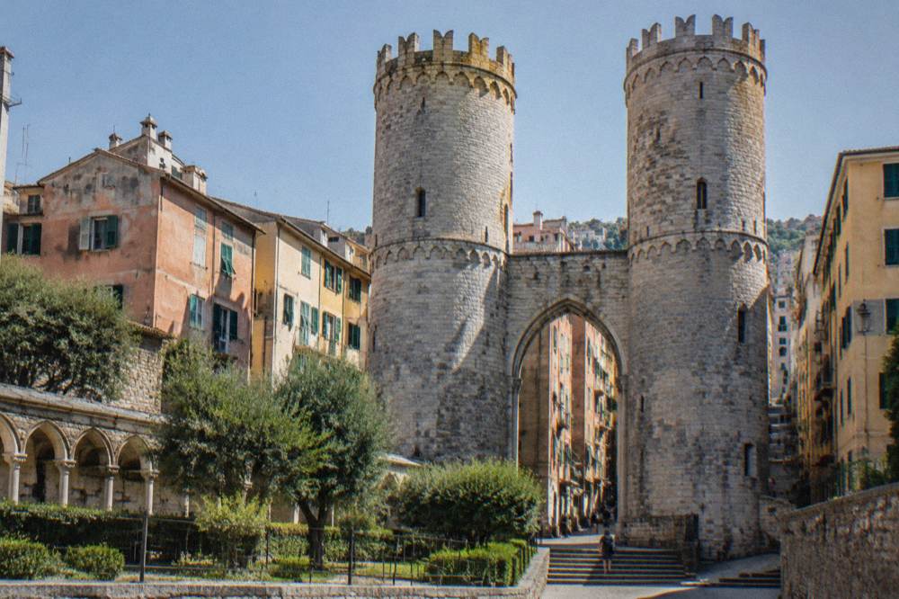Twin stone towers of a medieval gate seen from below against the sky