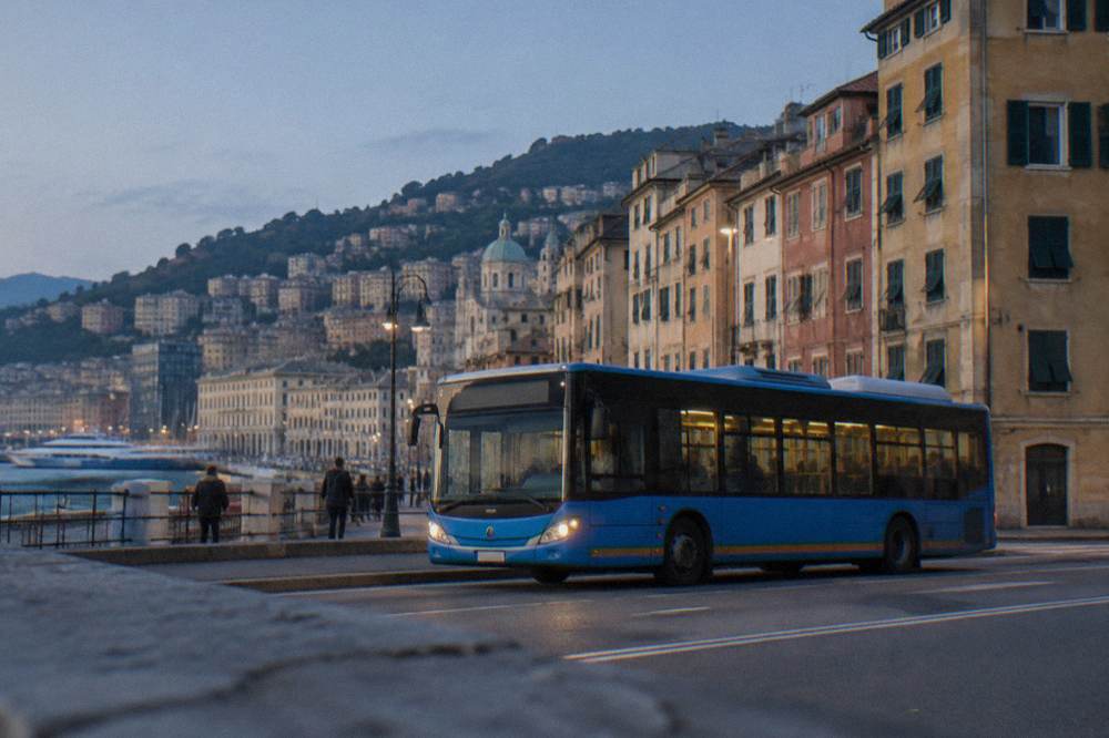 An AMT city bus on a Genoa street near the seafront with apartment buildings behind it