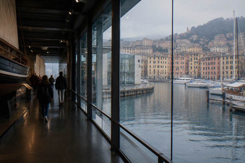 Visitors walking through a dimly lit museum corridor with ship displays