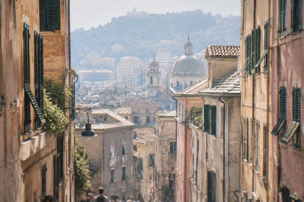 Narrow lane in the old town of Genoa with tall shuttered buildings
