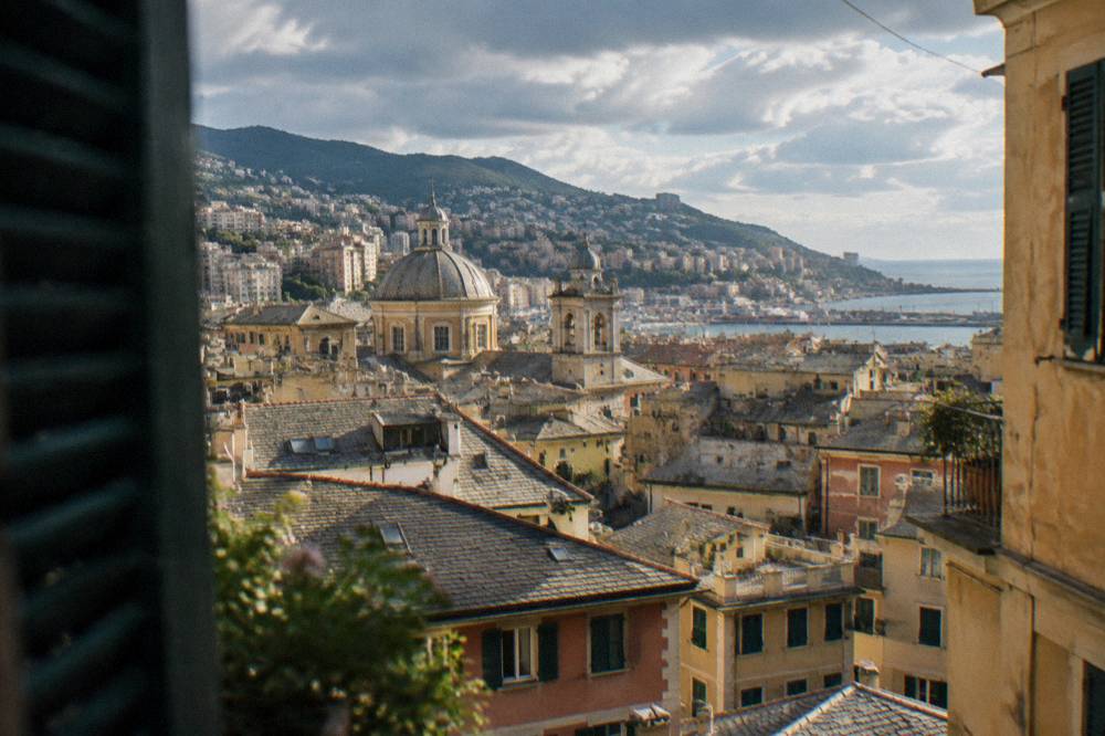 View over the rooftops of Genoa old town toward the hills and the sea
