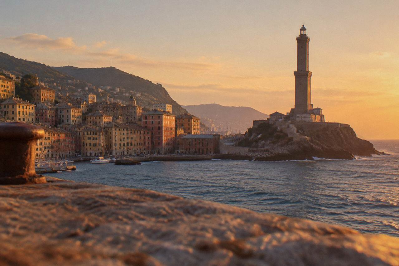 The stone tower of the Lanterna lighthouse rising above the harbour of Genoa