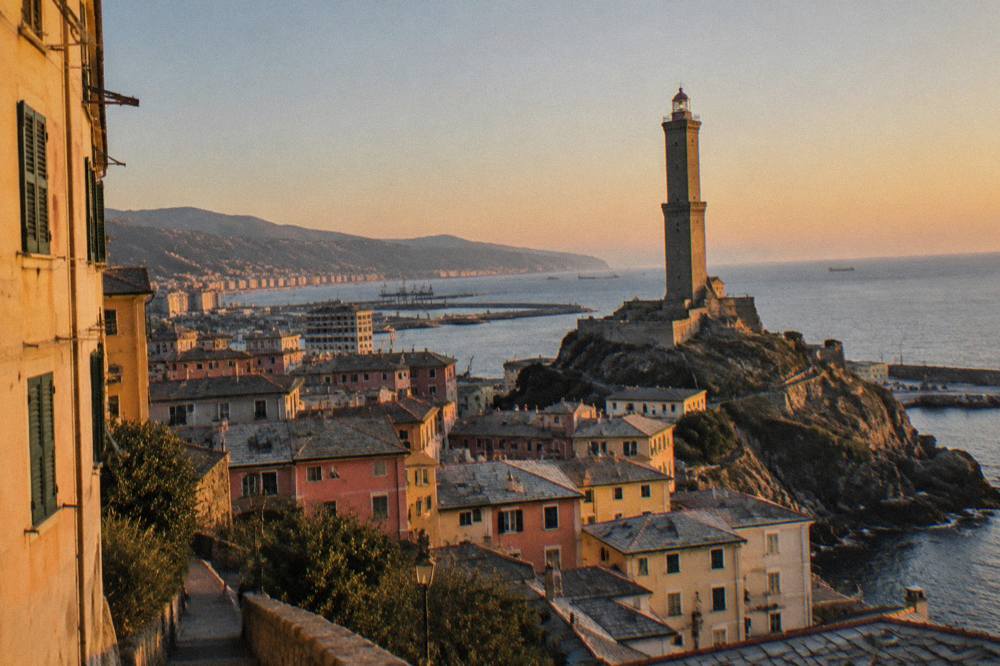 The Lanterna lighthouse under a clear sky with calm sea along the Genoa coast