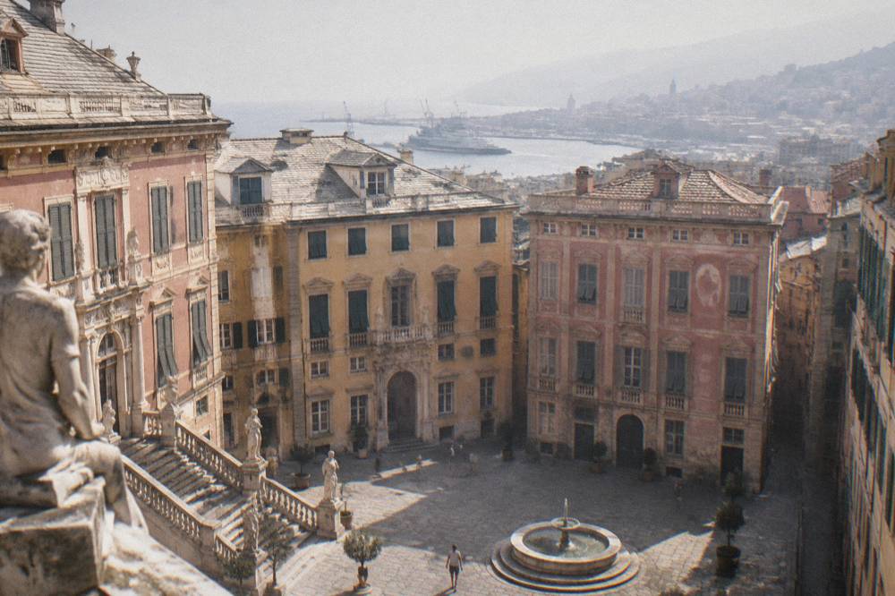 An ornate palace courtyard with columns, statues and a grand staircase open to the sky