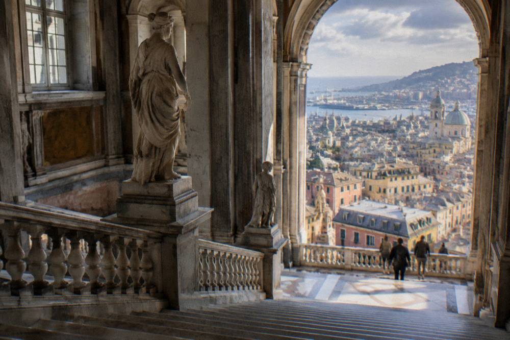 Grand marble staircase inside a Genoa palace with statues and balustrade