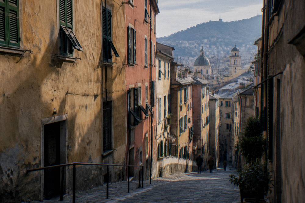 Narrow medieval lane with tall coloured buildings in Genoa's old town