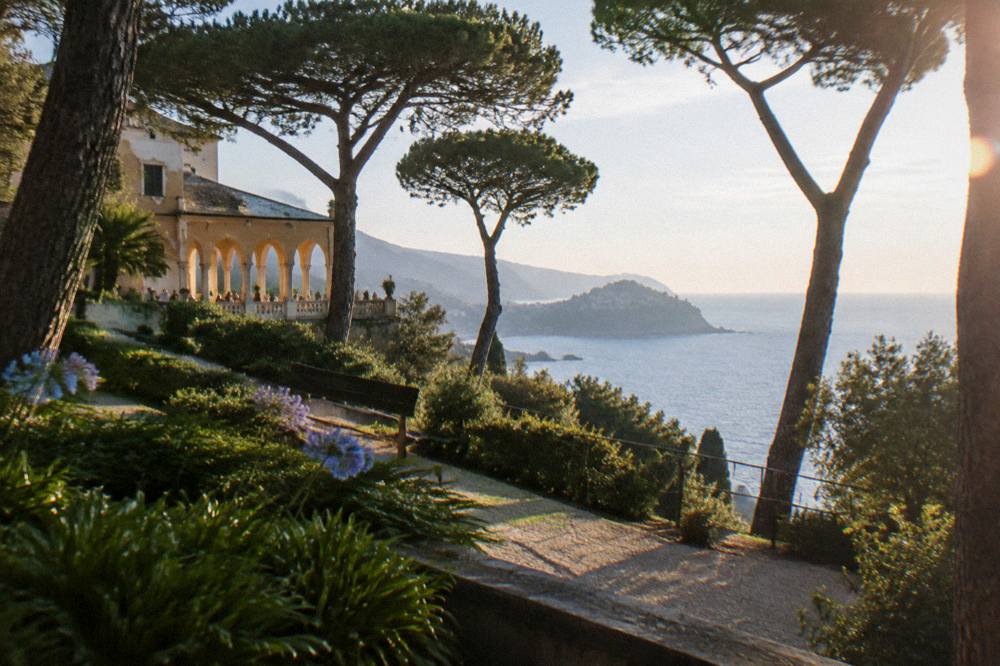 View over a garden terrace toward a distant coastal headland on the Ligurian Sea