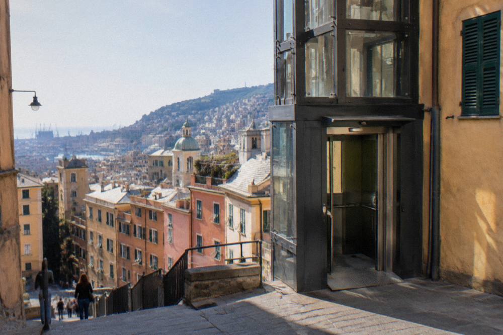 Exterior of a public elevator building on a Genoa street with signage