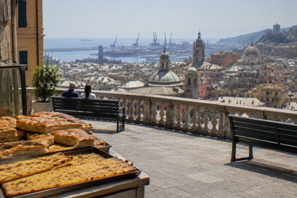 Freshly baked focaccia and farinata slices on a bakery counter