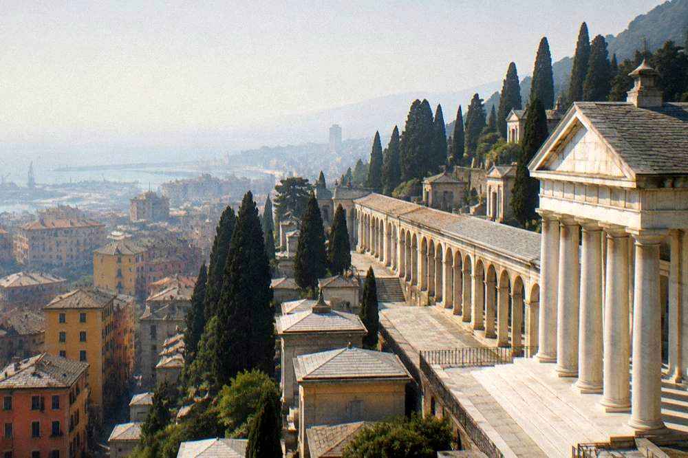 A vast neoclassical cemetery with long covered arcades and a columned portico of pale marble, a stepped hillside of cypress trees, empty and quiet