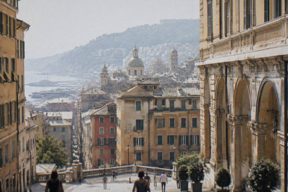 Stone palaces with arcaded courtyards along a wide street in Genoa