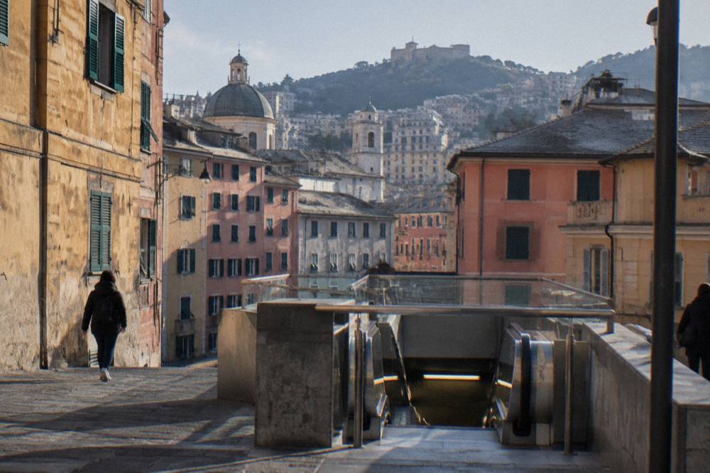 A metro station entrance in central Genoa with the AMT sign above the stairs