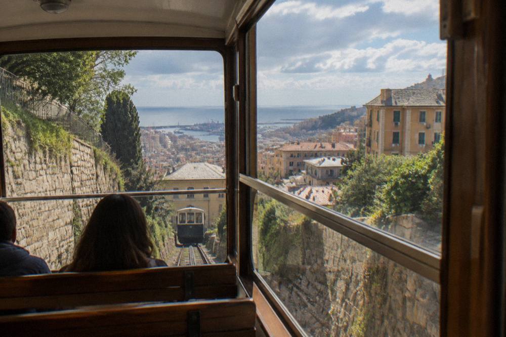 The interior of a funicular carriage with wooden seats and large windows