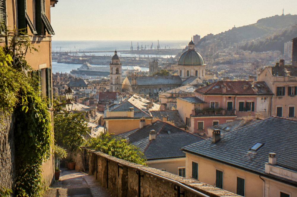 Sunset light over the tiled roofs of Genoa seen from a hillside path