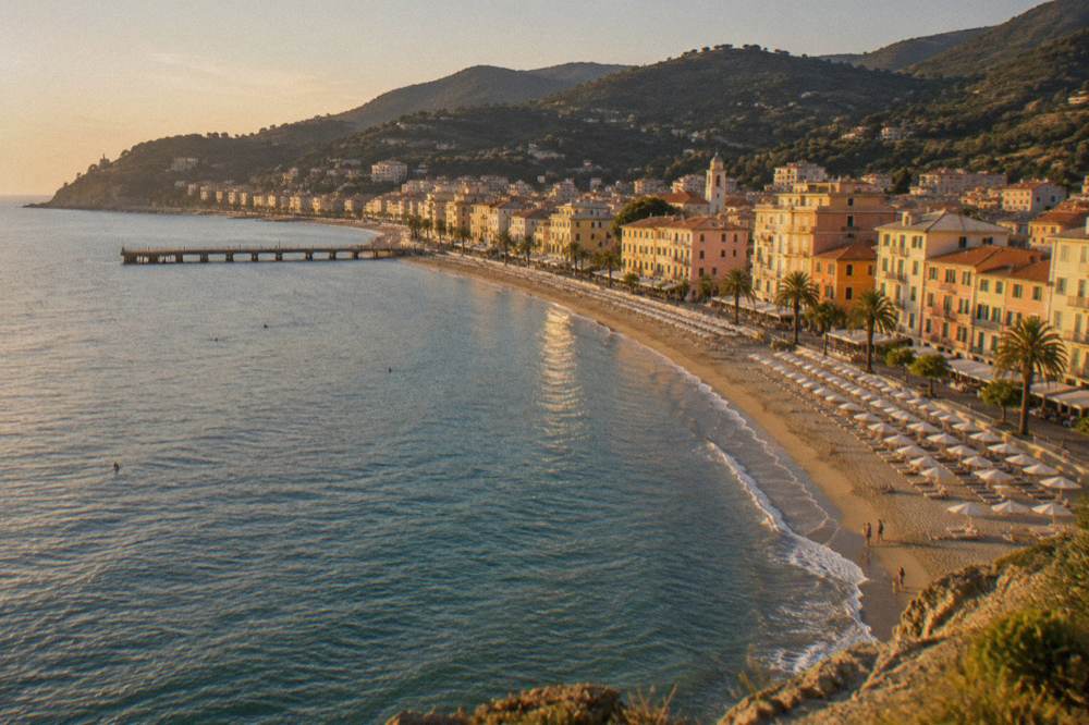 A pastel Ligurian seaside town seen from the water with hills rising behind