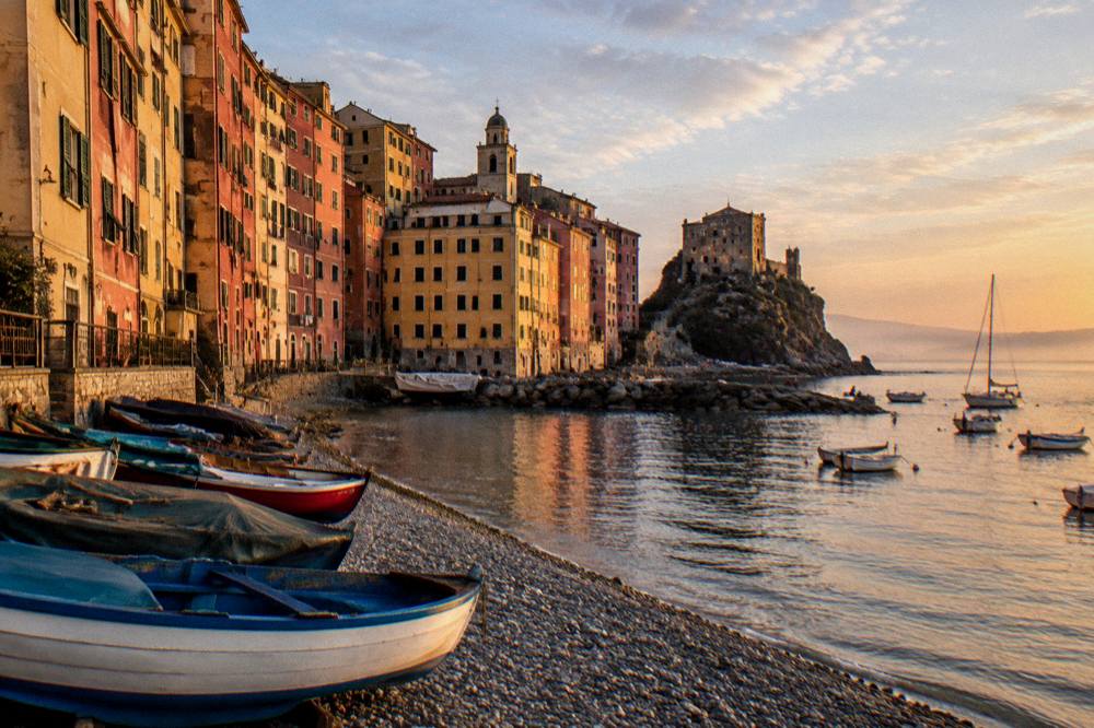 Golden evening light on a harbour with painted buildings and moored boats