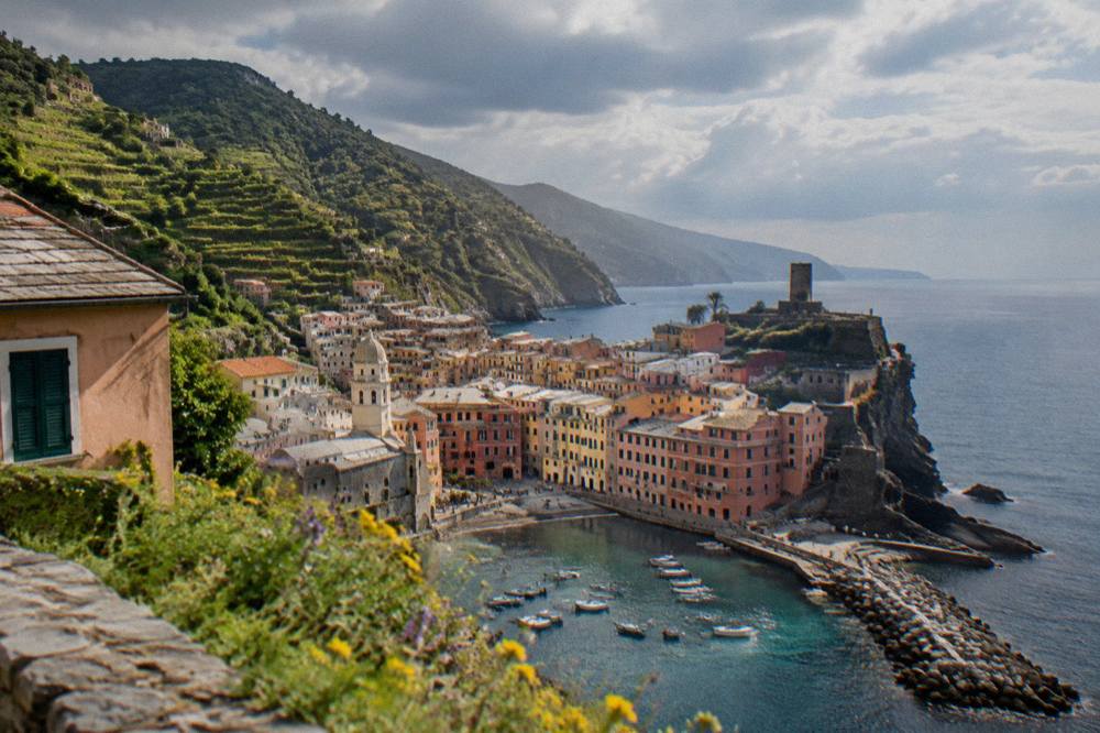 Clouds passing over terraced hills and a calm sea on the Ligurian coast