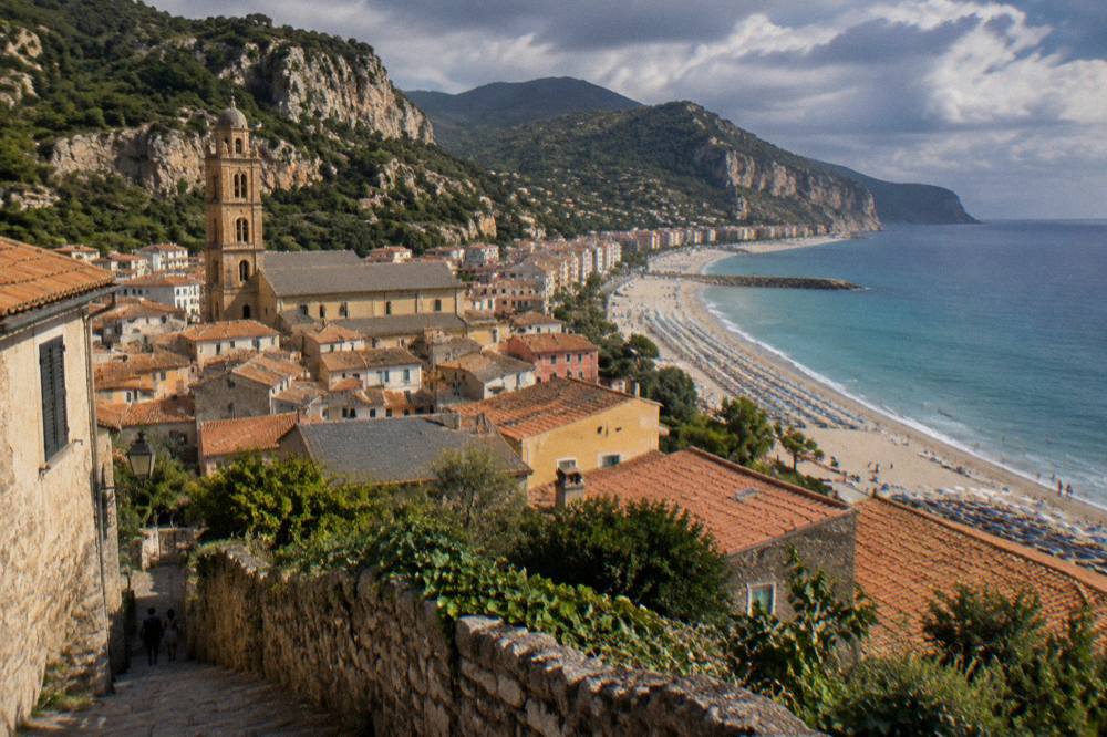 A wide sandy beach with rows of umbrellas along a Ligurian seafront