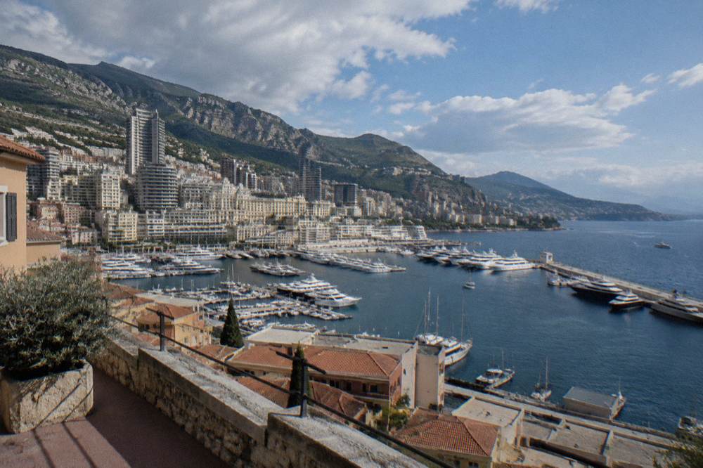 Harbour with yachts moored beside stone quays and hills behind