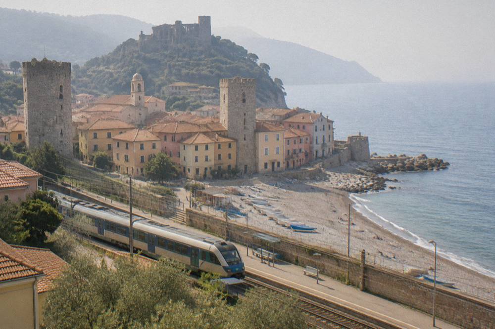 A regional train calling at a coastal station with the sea behind the platform