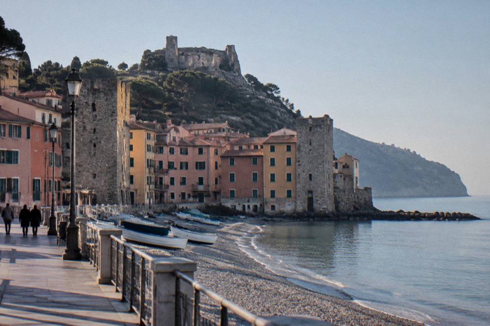 A coastal promenade under a clear sky with calm sea and distant headland