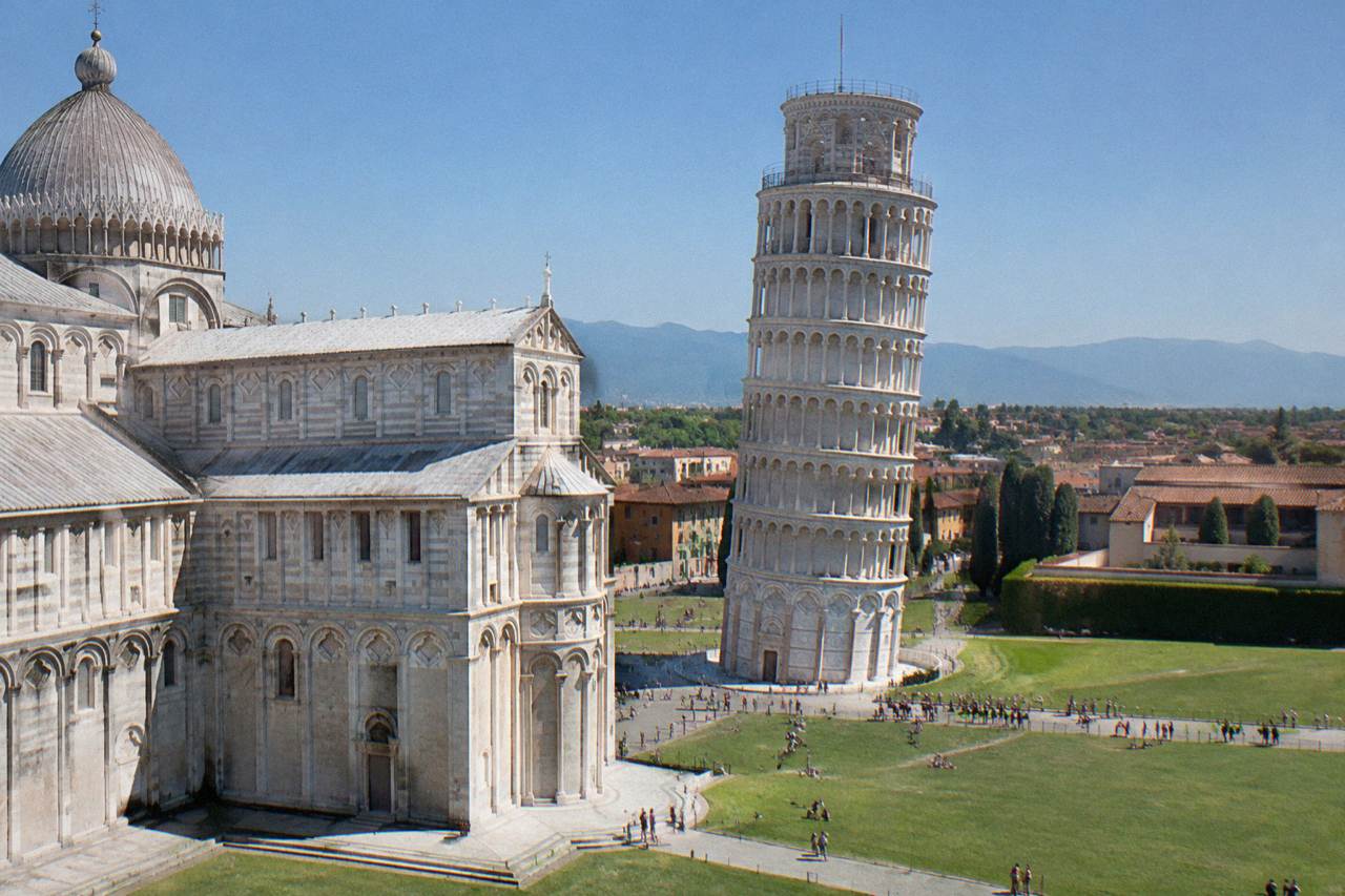 The Leaning Tower of Pisa standing beside the cathedral on a sunny morning