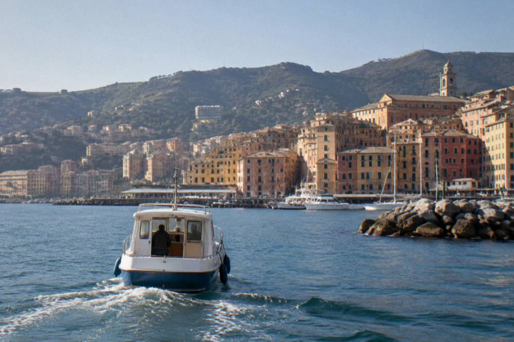 A boat approaching a small harbour on the Ligurian coast